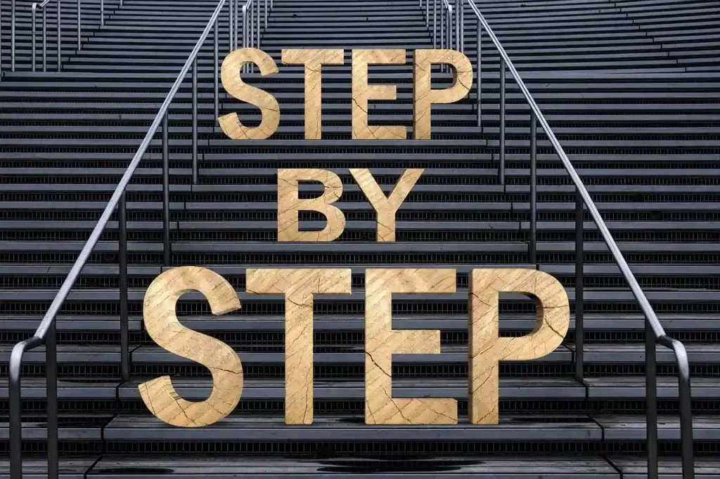 photo of a staircase, with the words "step by step" written on the steps