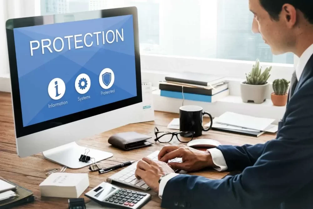 a man working on a laptop and the laptop screen says protection