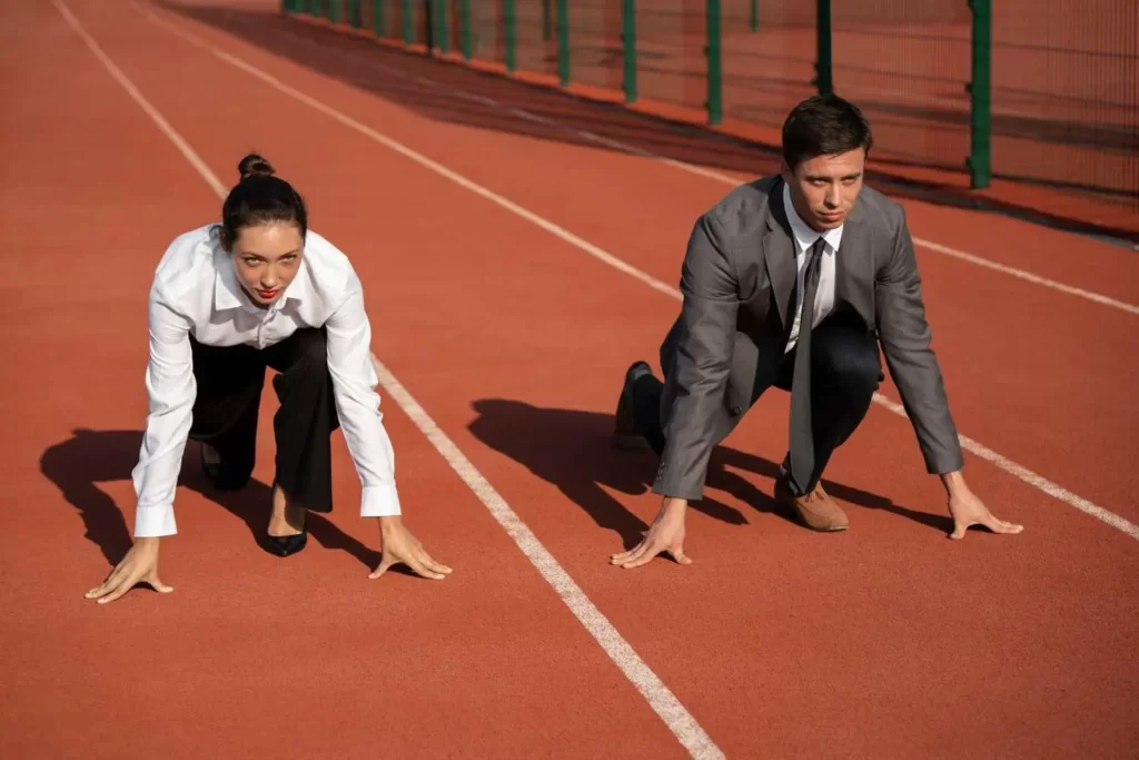 a man and woman prepared to run on an athletics running track