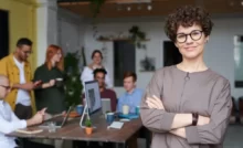 a confident woman and a team working in the background