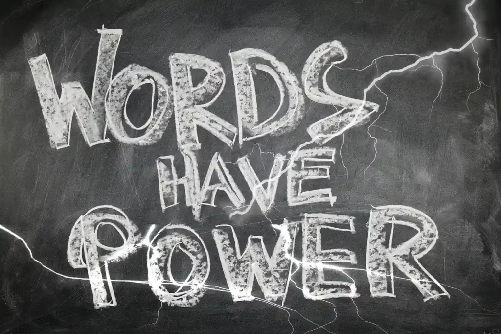 photo of a blackboard with the words written in chalk words have power and rays drawn