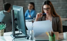 accountability in the workplace: a woman sitting at a writing table reviewing documents