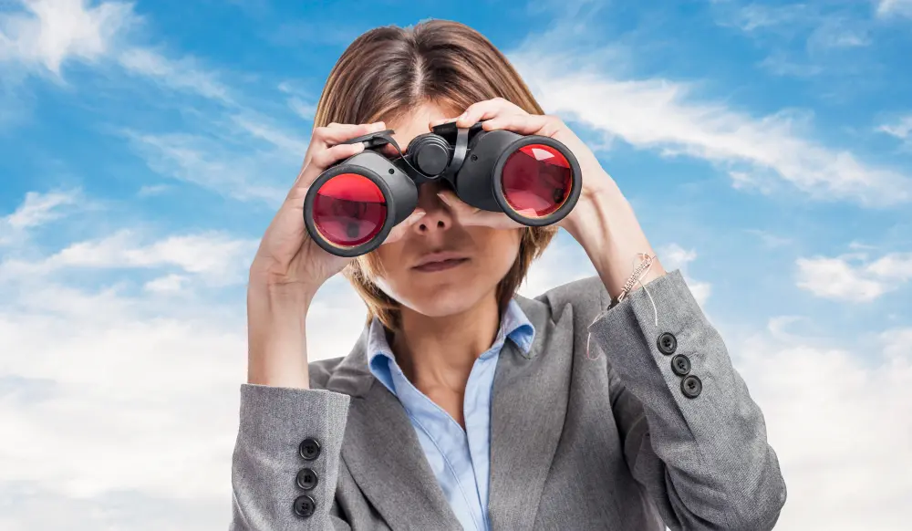 cazatalentos: una mujer que usa binoculares en busca de un talento