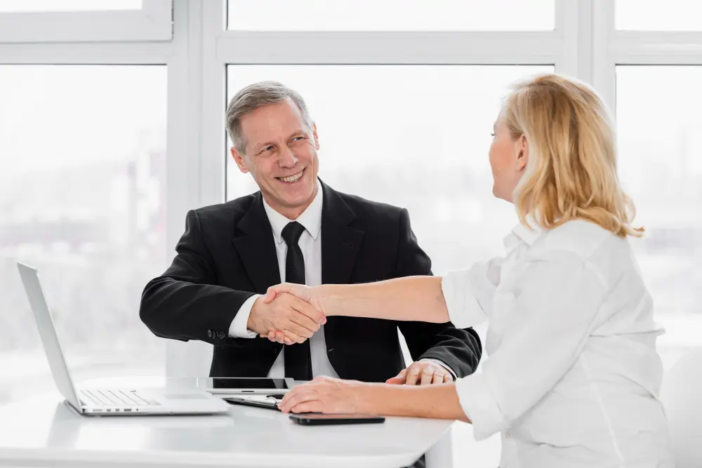 headhunter find c-level: a man and woman shaking hands in an office