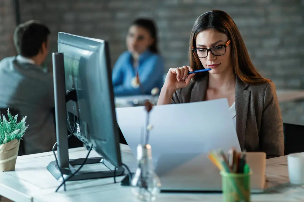 responsabilidad en el lugar de trabajo: una mujer sentada en un escritorio revisando documentos