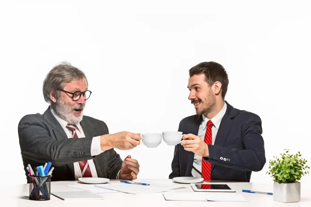 dos hombres brindando una taza de café