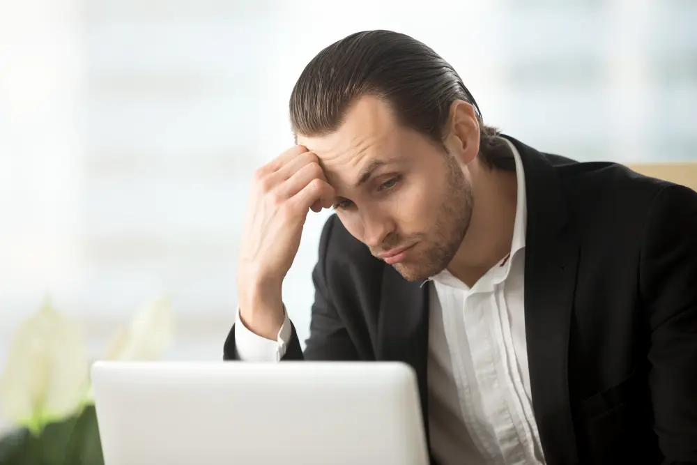 turn down a job offer: a bored man looking at his laptop
